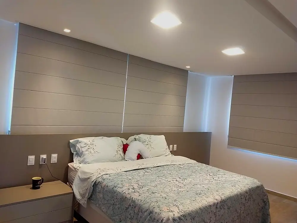 Quarto com cortina wave clara e cabeceira estofada.