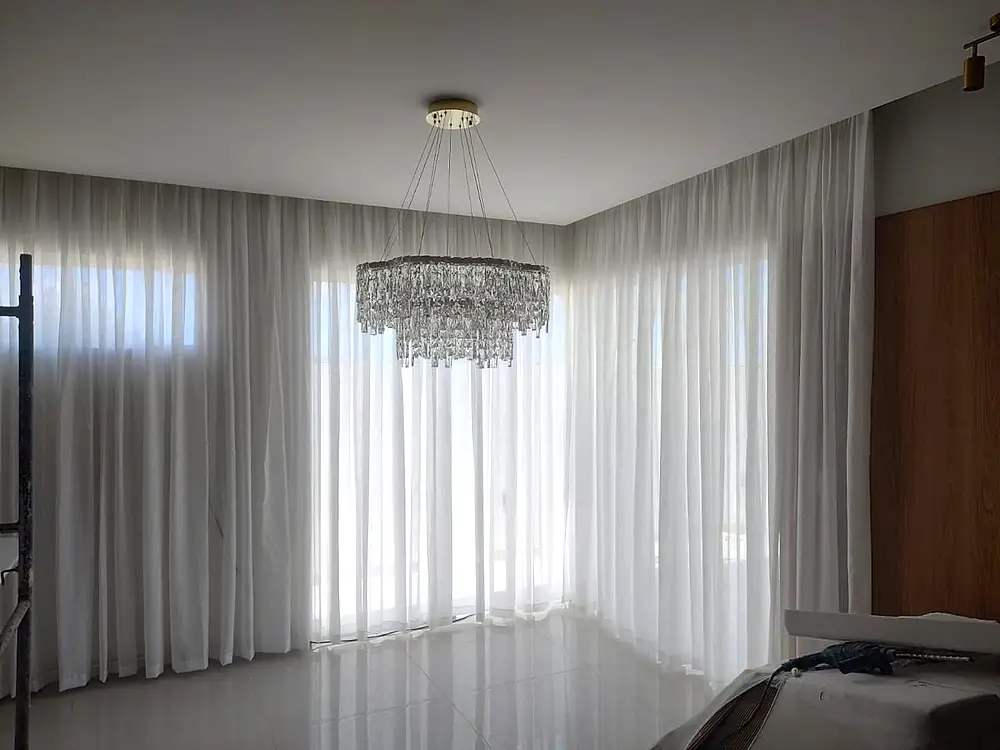Sala de estar com cortina wave em linho diante de uma janela alta.