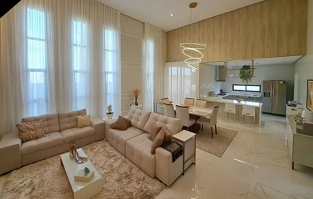 Sala de estar de pé-direito alto com cortina wave e sofá claro