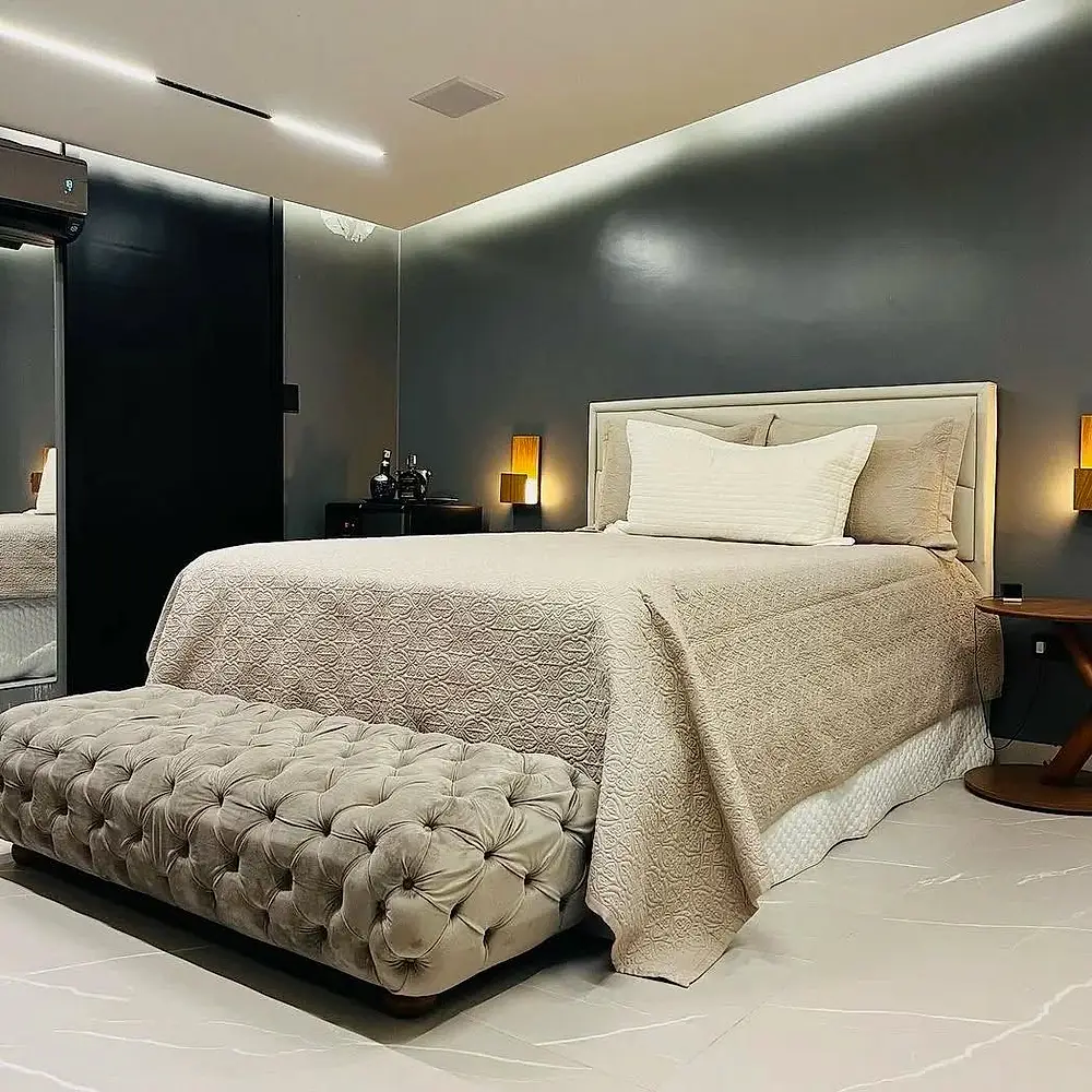 Quarto com cabeceira capitonê e cortina clara na janela