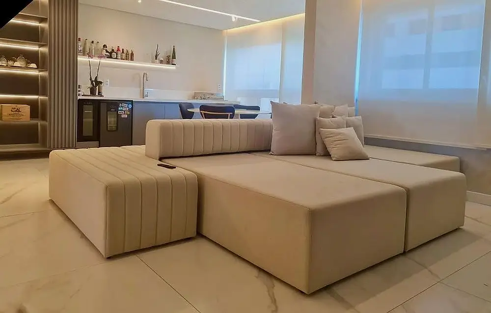 Sala ampla com cortina rolô e sofá de canto claro